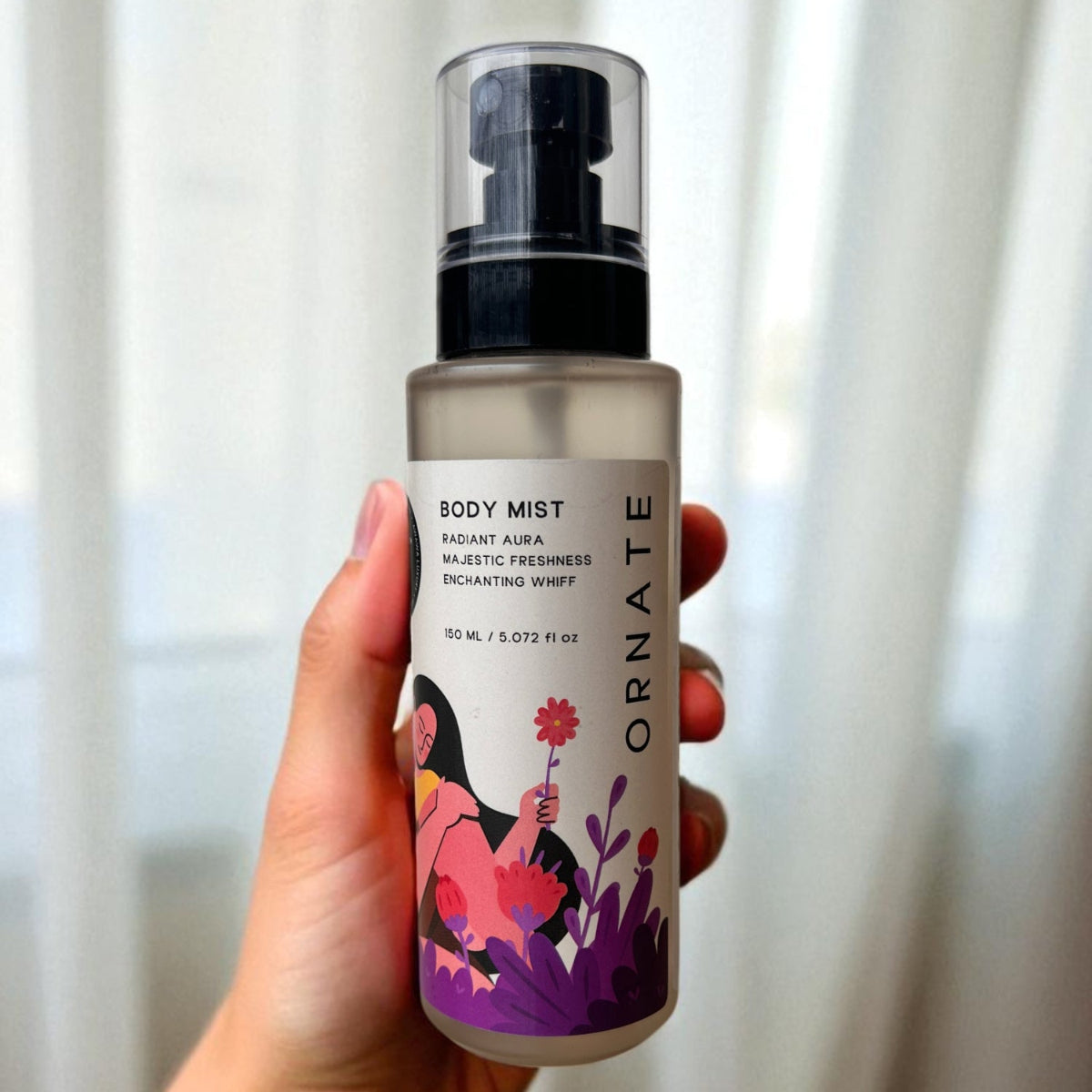 Awawa Luxury Ornate body mist bottle with floral design held in hand against white background